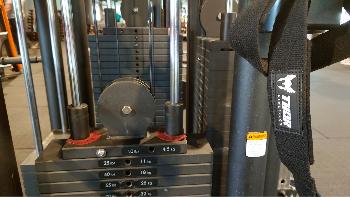 Straps in een sportschool die aan een kabelmachine hangen