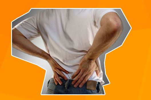 Een man die met twee handen in zijn onderrug drukt