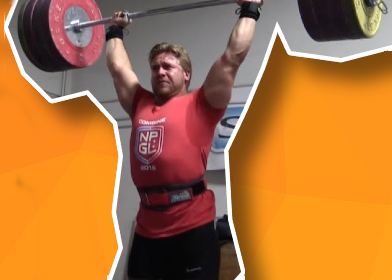 Man die lifting belt draagt duwt halter boven zijn hoofd uit