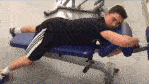 Jongen in sportschool ligt te slapen op een blauwe fitnessbank